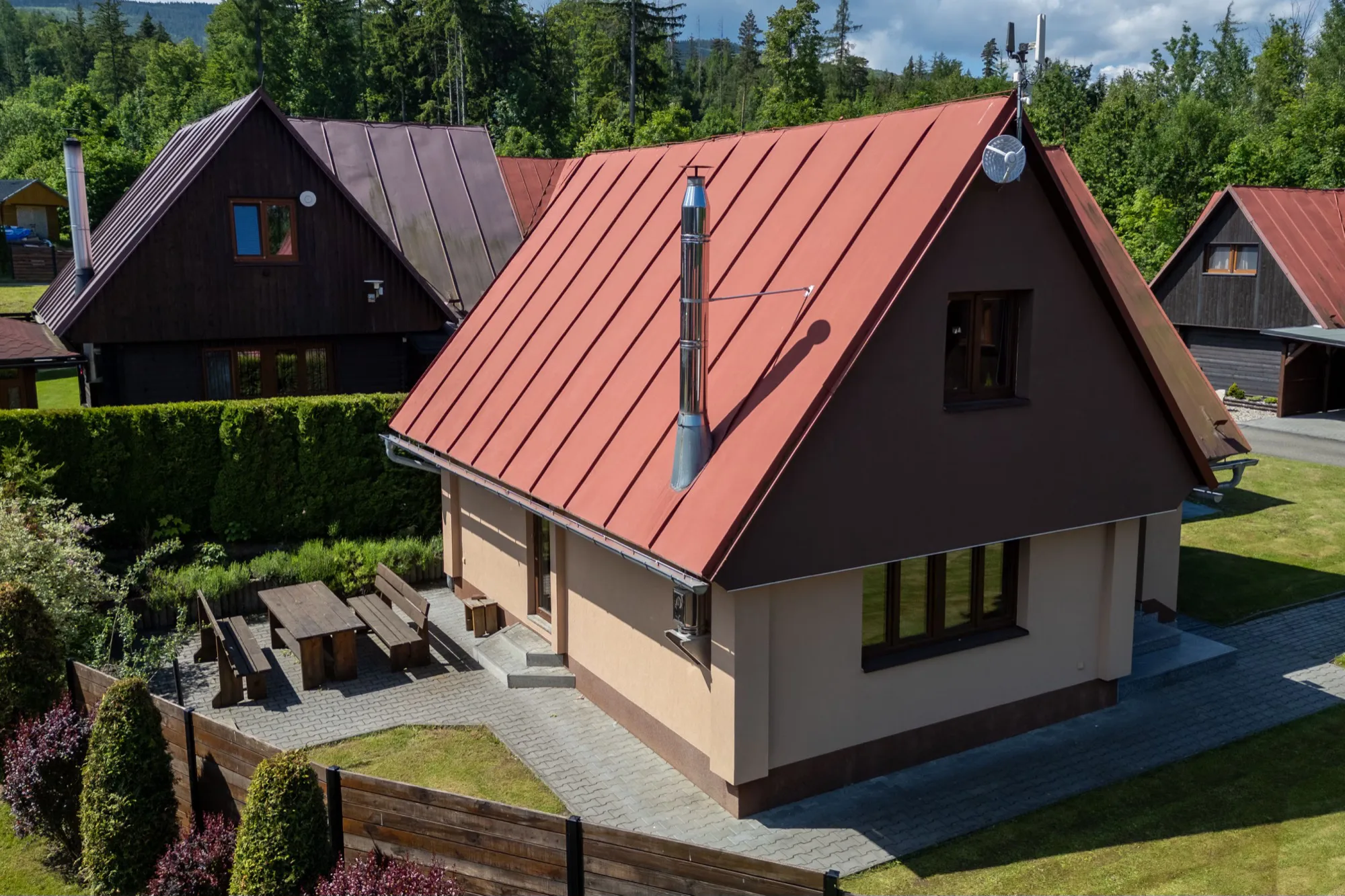 Chata s červenou střechou mezi stromy